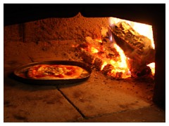 La cottura della pizza nel forno a legna